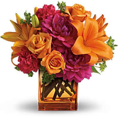 <p>Feeling hot, hot, hot! This sizzling summer floral arrangement mixes hot pink dahlias and carnations with bright orange roses and lilies in an orange cube vase. It’s the floral equivalent of a trip to Miami in July!<br />
Light orange roses, orange asiatic lilies, hot pink dahlias and hot pink carnations are presented with fresh green bupleurum in an orange glass cube vase.</p>